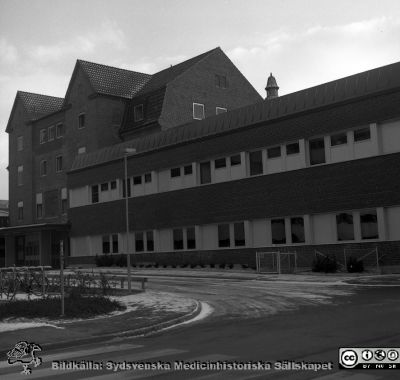 Gamla ortopediska kliniken, nu 1976 ombyggd och utökad till ny kvinnoklinik
Sjukhusfotograferna i Lund. Pärm negativ, S/V. 1976. 32.  Nya  kvinnokliniken, ursprungligen byggd som ortopedisk klinik i början på 1930-talet, och nu nyrenoverad och utökad. Foto från nordväst, ungefär från dåvarande radiologiska klinikens patientingång. Klinikens patientingång syns till vänster i bilden. Från negativ.
Nyckelord: Lasarett;Lund;Universitet;Universitetssjukhus;USiL;Kvinnoklinik;Klinik;Gynekologisk;Barnbördsklinik;BB