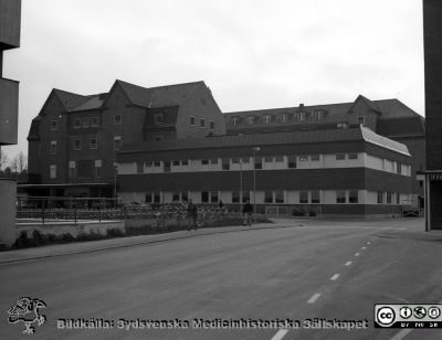 Gamla ortopediska kliniken, nu 1976 ombyggd och utökad till ny kvinnoklinik
Sjukhusfotograferna i Lund. Pärm negativ, S/V. 1976. 32.  Nya  kvinnokliniken, ursprungligen byggd som ortopedisk klinik i början på 1930-talet, och nu nyrenoverad och utökad. Foto från nordväst. Lasarettets centralblock till vänster i bild och dåvarande radiologiska klinikens patiententré till höger. Från negativ
Nyckelord: Lasarett;Lund;Universitet;Universitetssjukhus;USiL;Kvinnoklinik;Klinik;Gynekologi;Barnbördsklinik;BB