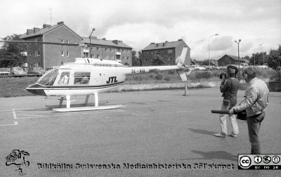 Räddningshelikoptern har landat!
Sjukhusfotograferna i Lund. Pärm Negativ, 1979:2.102. Ambulanshelikopter på plattan vid ambulansgaraget och panncentralen. Lasarettets informationsavdelning filmar för landstinget. Foto: 79-07-20. Från negativ. 
Nyckelord: Lasarettet;Lund;Universitetssjukhus;USiL;Ambulans;Helikopter;Information