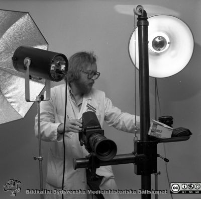 Sjukhusfotograf Bo Wiberg i fotoateljén
Sjukhusfotograferna i Lund. Pärm Negativ, 1979:2. 132. 79-10-24. B. Atelje. Fotograf Bo Wiberg. Från negativ. 
Nyckelord: Lasarettet;Lund;Universitetssjukhus;USiL;Fotoavdelningen;Mediaservice;Fotograf;Kamera;Ateljé