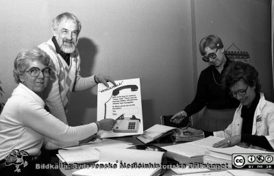 Ny telefonväxel 1982
Sjukhusfotograferna i Lund. Pärm S/V neg, 82:1. 59. Telefonföreståndaren (Birgit Svensson) tillsammans med driftschefen, ing. Mark Blomberg, telefonisterna Ingrid Walldén och Ulla-Britt Pehrson. De två till höger deltog i mycket skrivarbete inför den nya växeln 1982. 82-04-19. Från negativ.
Nyckelord: Lasarettet;Lund;Universitetssjukhuset;USiL;Telefon;Växel