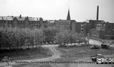 Vy söderut över c-blockets tomt, ännu obebyggd, 1961
Pärm Lasarettsfoto, interiörer och exteriörer m.m. 1958 - 1960. LAS. Exteriör, 61. 23. Foto 1961 från någon av de översta planen på AB-blocket. Vy söderut. Från vänster ses i fonden dåvarande ortopediska kliniken (senare kvinnoklinik), en liten del av medicinska kliniken, öronkliniken med Allhelgonakyrkans torn bakom och radiologiska kliniken med den ännu inte rivna skorstenen vid gamla panncentralen bakom. Schaktning för det bliviande centralblocket har påbörjats i förgrunden. Från negativ.
Nyckelord: Lasarettet;Lund;Universitetssjukhus;Universitet;USiL;Ortopedi;Medicin;Klinik;_Öron;Radiologi;Panncentral;Skorsten;Allhelgonakyrkan