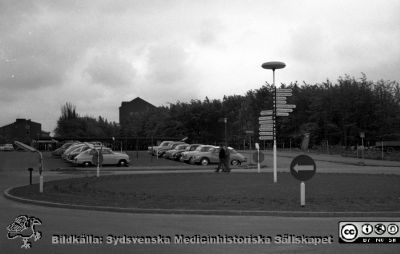 Lasarettet i Lund 1961.  Parkeringsplats alldeles söder om AB-blocket
Pärm Lasarettsfoto, interiörer och exteriörer m.m. 1958 - 1960. LAS. Exteriör, foto 1961. 24.Snart skall grunden här läggas för det nya centralblocket. Fysiologiska institutionen och psykiatriska kliniken i bakgrunen. Från negativ, flik 1960
Nyckelord: Lasarett;Lund;Universitet;Universsitetssjukhus;USiL;Bygge