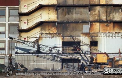 Fasadarbete och grävning för centralblocket
Pärm Lasarettsfoto, interiörer och exteriörer m.m. 1958 - 1960. Gropen grävs för C-blocket. Hitom fasaden på AB-blockets trapphus står den stora lyftkran som användes när fasaden på dess trapphus togs ned. Där skall C-blocket ansluta. Foto 1960. Från negativ. 
Nyckelord: Lund;Lasarett;Universitet;Universitetssjukhus;USiL;Blocket;Bygge;Grävning