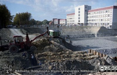 Grävning för det blivande laboratorieblocket
Pärm Lasarettsfoto, interiörer och exteriörer m.m. 1958 - 1960. Gropen för det blivande laboratorieblocket. AB-blocket till höger i bakgrunden. Trapphusets fasad har ännu inte plockats ned.  Längre bort den då nya administrationsbyggnaden. Foto 1960. Från negativ
Nyckelord: Lund;Lasarett;Universitet;Universitetssjukhus;USiL;Blocket;Bygge;Grävning