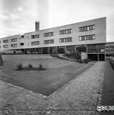 Lasarettshemmet, oktober 1965
Pärm Lasarettsfoto, interiörer och exteriörer m.m. 1958 - 1960. Exteriör, Lasarettshemmet, oktober 1965. Fasad mot väster. Till höger i bakgruden skymtas centrablocket på Lasarettet i Lund under uppförande. Från negativ. 
Nyckelord: Lasarett;Lund;Lasarettshem;Universitetssjukhus;USiL