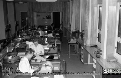 En expeditionsdisk i nya administrationsbyggnaden i Lund 1960
Pärm Lasarettsfoto, interiörer och exteriörer m.m. 1958 - 1960. En expeditionsdisk i nya administrationsbyggnaden vid Lasarettet i Lund (färdig 1960) där t.ex. utbetalning av lön gjordes i kontanter. Många gick hit en gång i veckan och hämtade ett litet kuvert med lönen i. Från negativ.
Nyckelord: lLasarettet;Lund;Universitet;Universitetsklinik;USiL;Administration;Kassa