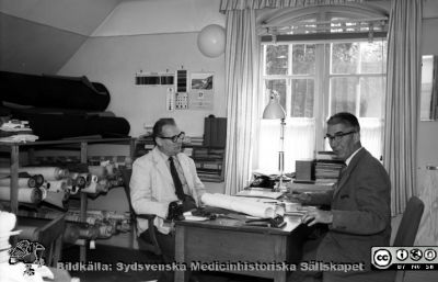 Maskinmästare Gösta Svensson och tapetserarmästare Malm 1960
Pärm Lasarettsfoto, interiörer och exteriörer m.m. 1958 - 1960. 17. Lokaler, Las. 1960. Interiör från möbel- och tapetserarverkstaden på södra lasarettsområdet. Bilderna 101104-38 och -61 är från sama fototillfälle och sägs visa "Mask.mäst. Gösta Svensson" (till höger i bild) och "Tapetserarmäst. Erik (?) Malm" (till vänster i bild). Från negativ.
Nyckelord: Lasarett;Lund;Universistet;Universitetssjukhus;USiL;MTA;Verkstad;Tapetserare;Teknik