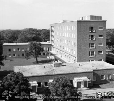 Barnkliniken från någon av de övre våningarna på radiologiska kliniken, 1958
Pärm Lasarettsfoto, interiörer och exteriörer m.m. 1958 - 1960.  Vy mot nordväst. 9/1958. Från negativ.
Nyckelord: Lasarettet;Lund;Universitetssjukhus;USiL;Barn;Pediatrisk;Klinik;Radiologisk