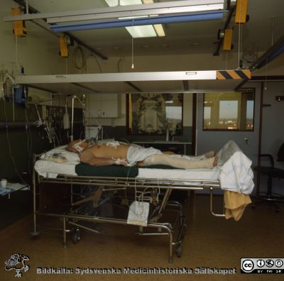 Uppvakningsavdelningen 1990
Sjukhusfotograferna i Lund. Plast-ficka, lösa bilder, 1980-90-talen. Nypopererad patient (troligen en bröstkorgsoperation), fortfarande sövd. Han ligger under ett värmetak. De var bra, men alltför ofta i vägen, och ersattes senare med värmefiltar vid behov. Foto: Roger Lundholm 1990 +/- några år. Från positiv.
Nyckelord: Lasarettet;Lund;Universitetssjukhus;USiL;KIVA;Intensivvård;Uppvakning;Postoperativ