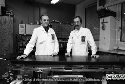 Från vänster Bert Persson och Bo Ericsson
Sjukhusfotograferna i Lund. Pärm Svart-vita neg. 1987. 142/-87. Medicinskt tekniska verkstaden. 16 nov. 1987. Från negativ.
Nyckelord: Lasarettet;Lund;Universitetssjukhus;USiL;MTA;Medicinsk;Teknik;Verkstad;Operationsbord