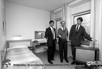 Tre adminsitratörer hälsar välkomna till ett rum i det nya patienthotellet
Sjukhusfotograferna i Lund. Pärm Svart-vita neg. 1987. 141/87. Från negativ.
