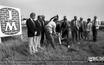 Första spadtaget för sjukvårdens centrallager på Gastelyckan i Lund 1988
Sjukhusfotograferna i Lund. Pärm Sv/v neg. 1988.	 29/-88. Info. 88-05-11. Spaden provas i jorden av byggfirmans medarbetare på Gastelyckan inför byggstarten av ett centralförråd där. Kanslichef Matts Wendel längst till vänster i bilden. De fyra längst till höger är från vänster Ulf Johansson (administratör) tillsammans med landstingspolitikerna Fredrik Swartling (m), Ulla Fredriksson (s) och Torvald Frostemark (c). Från negativ. 
Nyckelord: Lasarettet;Lund;Universitetssjukhus;USiL;Centralförråd;Bygge;Byggstart