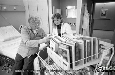 En bibliotekarie med en bokvagn på en patientavdelning 1988
Sjukhusfotograferna i Lund. Pärm Sv/v neg. 1988. 19/-88. En bibliotekarie från lasarettsbiblioteket med böcker i en vagn på en patientavdelning, 88-03-03./+03-88. Från negativ.
Nyckelord: Lasarettet;Lund;Universitetssjukhus;USiL;Bibliotek;Böcker;Bokvagn;Vårdavdelning;Vård;Avdelning