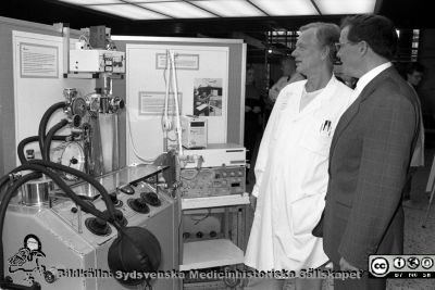 Medicintekniska föreningen i Lund 20 år
Sjukhusfotograferna i Lund. Pärm Sv/v neg. 1989. 72. Medicintekniska föreningen i Lund firar 20 år med en uställning utanför aulan och i centralblockets entréhall, okt, 1989, Docenterna Lars Nordström (narkosläkare) och Björn Jonson (klinisk fysiolog) vid två ventilatorer, en gammal Engström-resporator och en nyare, ServoVentilatorn, som de byggt och framgångsrikt introducerade. Den hade redan blviit ventilatorers gyllene standard. Från negativ.
