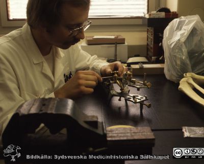 Instrumentmakare Bosse Eriksson
Pärm Lasarettsfotograferna, gamla färgbilder 1. 19. Instrumentmakare Bosse Eriksson i arbete, troligen med en ortopedisk borrgigg. Skelettdelarnat till höger i bild antyder att han sysslar med något ortopediskt. Från positiv
Nyckelord: Lasarettet;Lund;Universitetssjukhus;USiL;Verkstad;Medicinsk;Teknik;Ortopedi;Skelett;MTA