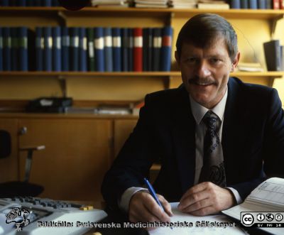 Redovisningschefen Hasse Igeby 
Pärm Lasarettsfotograferna, gamla färgbilder 1. 104. Redovisningschefen Hasse Igeby på administrativa avdelningen. Foto troligen på 1980-talet. Från positiv.
Nyckelord: Lasarettet;Lund;Universitetssjukhus;USiL;Administration;Redovisning