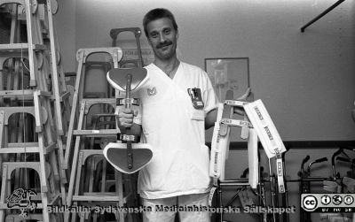 Sjukgymnasten Håkan Andreasson
Pärm Lasarettsfotograferna i Lund, Pärm negativ, 1990. 8. 1990. Sjukgymnasten Håkan Andreasson på Ortopediska Kliniken med den  3-punktskorsett som han hade konstruerat för att fixera ryggen i "rakt" läge vid kotkompressioner. Korsetten var billigare och bättre än tidigare versioner. Han fick pris av sjukhusets förslagsnämnd för detta. Foto 31/1-1990. Från negativ.
Nyckelord: Lasarettet;Lund;Universitetssjukhus;USiL;Ortopedisk;Klinik;Teknik;Fysikalisk;Medicinsk;Utmärkelse