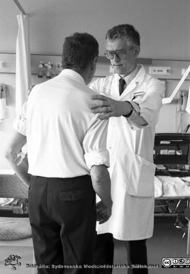 Docent Olle Lindvall (sedemera professor) med patient 1990
Pärm Lasarettsfotograferna i Lund, Pärm negativ, 1990.  55. Neurologiska kliniken. Från negativ.
Nyckelord: Lasarettet;Lund;Universitetssjukhuset;USiL;Neurologiska;Kliniken;Restorativ