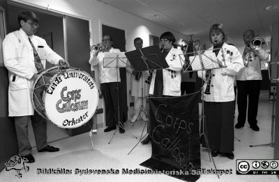 Invigning på neurologiska intensivvårdsavdelningen (NIVA)
Lasarettsfotograferna i Lund,  pärm S/V Neg. 1996. 96. 7. Orkestern Corps Callosum orkester spelar. Den har sina rötter på neurokirurgiska kliniken. Neurokirurgen, docent (senare professor) Bertil Romner vid stora trumman. Från negativ.
Nyckelord: Lasarettet;Lund;Universitetssjukhuset;USiL;NIVA;Invigning;Neurologisk;Neurokirurgisk;Klinik