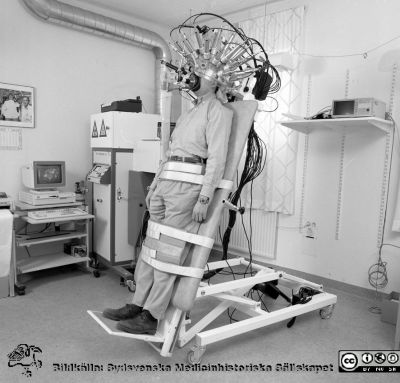 Jarl Risbergs apparat för mätning av cerebralt blodflöde
Lasarettsfotograferna i Lund,  pärm S/V Neg. 1996. 28, 96. Jarl Risbergs apparat för mätning av cerebralt blodflöde, här i uppfällt läge för att mäta kroppsläget inverkan på blodflödet i hjärnan. Kanske är det Jarl Risberg själv i maskinen. Se också bild SMHS14194, SMHS14195, SMHS15159, SMHS15164, USiLx-1651 och USiLx-1316. Från negativ.
Nyckelord: Lasarettet;Lund;Universitetssjukhuset;USiL;CBF;Cerebralt;Blod;Flöde;Laboratorium