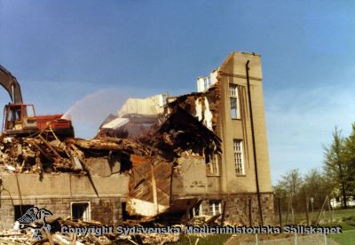 En gammal paviljong rivs år 1980
Vipeholm exteriört. Paviljong A rivs år 1980. Foto, omonterat
Nyckelord: Vipeholm;Exteriört;Paviljong;Rivning;Foto;Omonterat;Kapsel 15;1980