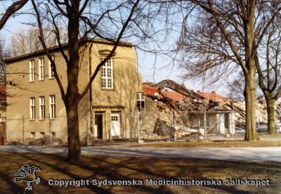 En gammal paviljong rivs år 1980
Vipeholm exteriört. Paviljong rivs år 1980. Foto, omonterat
Nyckelord: Vipeholm;Exteriört;Paviljong;Rivning;Foto;Omonterat;Kapsel 15;1980