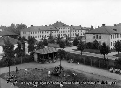 Promenadgård och manliga paviljonger, Vipeholms sjukhus
Vipeholm exteriört. Rastgård. Manlig paviljong. Allléträden i anläggningens mittgång är ännu relativt små, så fotot bör vara taget nära mitten på 1900-talet. Bilden finns publicerad på sid 87 i Carlén-Nilsson C, Holmér U (1998) Röster från Vipeholm. pp. 1-127 Stiftelsen medicinhistoriska museerna i Lund och Helsingborg, Lund.
 
Annan kopia av samma negativ: SMHS1678 avsedd för Kulturens bilddatabas Carlotta.
Nyckelord: Vipeholm;Paviljong;Manlig;Rastgård;Promenadgård;Foto;Omonterat;Kapsel 15