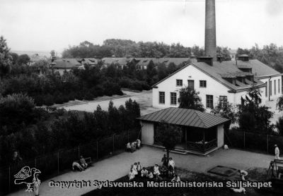 Vipeholms sjukhus, pannhuset
Vipeholm exteriört, Utsikt från paviljong A. Promenadgård för manliga patienter, med väderskydd. Pannhus / maskincentral i bakgrunden. Foto rimligen från mitten av 1900-talet, omonterat
Nyckelord: Vipeholm;Exteriört;Utsikt;Paviljong A;Foto;Omonterat;Kapsel 15;Panncentral;Maskinhus;Promenadgård;Väderskydd