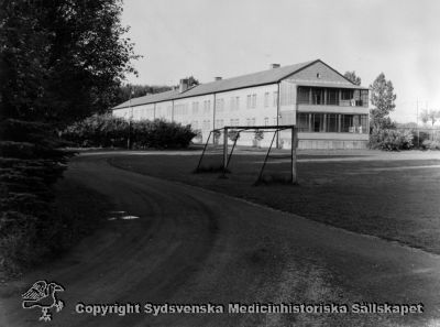 Kvinnlig paviljong, med idrottsplatsen framför. 
Vipeholm exteriört. Foto under 1900-talets andra halva, omonterat
Nyckelord: Exteriört;Vipeholm;Kapsel 15;Foto;Omonterat;Fotbollsplan;Idrottsplats;Paviljong;Kvinnlig