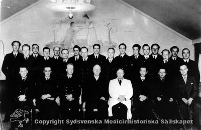 Högre kurs för skötare, St Lars och Vipeholms sjukhus, 1945
Vipeholm utbildn. personal. Högre kurs för sjukvårdspersonal på Vipeholms sjukhus 1945, med deltagare från Sankt Lars och Vipeholms sjukhus, samlade i den sal som gemenligen gick under namnet "Kasinot". Övre raden från vänster: Nils Tore Bengt Jonsson, Harry Sixten Anders Crantz, Gunnar Ferdinand Olsson, Nils Gustav Bardolf Jönsson, Herman Lennart Larsson, Malte Einar Brönnert, Tore Egon Höglund, Artur Bror Algot Fridén, Yngve Arvid Pontus Paulsson, Karl Walter Sundh, Erik Hjalmar Gustavsson, Karl Larsson, Henning Rudolf Axelsson, John Herman Löndahl. Nedre raden från vänster: Ragnar Björnmark, Nils Hilding Arnsäter, Erik Vilhelm Nilsson. Professor Einar Sjövall, Överläkare Hugo Fröderberg, Tore Hjalmar Pettersson, Josef Edvin Håkansson, Lars Erik Torsten Andersson.  	Foto	Omonterat
Nyckelord: Vipeholm;Utbildning;Personal;Sankt Lars;Kasinot;Foto;Omonterat;Kapsel 16;1945