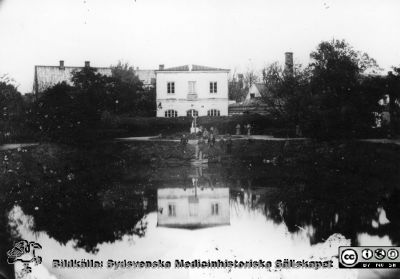 Norra delen av Lundgård på 1870-talet med dåvarande Lasarettet i Lund i bakgrunden
Ur pärm med bilder tänkta för A. Flaum "Lasarettet i Lund" (1968). Foto från 1870-talet (B.A.Lindgren), taget från gamla botaniska trädgården med dess spegeldamm och orangeri. Till höger ser man kurhuset samt maskin- och tvätthuset med dess skorsten. Till vänster skymtar man en del av äldsta barnbördshuset och bakom detta "nya lasarettet" (senare ungkliniken). Byggnadsnämndens arkiv, Lund. Ej medtagen i Flaum 1968.
Nyckelord: Lasarettet;Lund;Universitetssjukhuset;USiL;Historik;Park;Lundagård