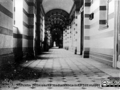 Korridor i kirurgiska kliniken av år 1867-68
Ur pärm med bilder tänkta för A. Flaum "Lasarettet i Lund" (1968). Kirurgklinikens korridorer omkring 1900. (obs. kaminer). Ej återfunnen i Flaum 1968.
Nyckelord: Lasarettet;Lund;Universitetssjukhuset;USiL;Kirurgisk;Klinik;Korridor;Kamin