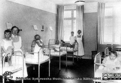 Interiör från barnkliniken i Lund, första halvan av 1900-talet
Ur pärm med bilder tänkta för A. Flaum "Lasarettet i Lund" (1968). Sjuksal på gamla barnsjukhuset. Foto: Otto Ohm, Malmö. Troligen ej med i Flaum 1968.
Nyckelord: Lasarettet;Lund;Universitetssjukhuset;USiL;Pediatrisk;Klinik;Barnklinik