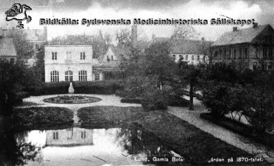 Gamla botaniska trädgården i Lund med dess spegeldamm i förgrunden och orangeri. Vy norrut. 
Till höger ser man anatomicum (senare teologicum och arkeologisk institution), gamla kurhuset samt maskin- och tvätthus med dess skorsten. Till vänster därom en del av det äldsta barnbördshuset och bakom detta "nya lasarettet" från 1850, senare radiologisk klinik, lungklinik mm. 
Foto B.A. Lindgren på 1870-talet. Publicerad i Flaum 1968, sid 112.
Nyckelord: Kapsel 01;Regionarkivet;Universitet;Lund;Anatomicum;Kurhus;Orangeri;Lund;Universitetplatsen;Paradis
