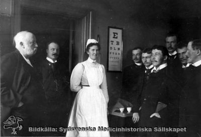 Ögonkliniken i Lund på södra lasarettsområdet, 1903.
Professor Löwegren i sin klinik. T.v. dåvarande docenten, sedermera professorn i oftalmiatrik Albin Dalén, t.h. tjänstgörande vid kliniken Gustaf Pallin, Emil Westergård, Herold Hisrschlaff, Herman Wallengren och Sven Johansson. Ur med. hist. sällsk. årsskrift 1971. Sid 67. MS 5.559. - Sköterskan hette Karla Theresia Löwenadler, f. 1867 i Eksjö, enligt påskrift på en annan kopia av denna bild, funnen 2010 på Ögonkliniken i Lund.
Nyckelord: Kapsel 02;Regionarkivet;Lasarettet;Lund;Ögonkliniken;1903;Löwegren;Albin;Dalén;Gustaf;Pallin;Emil;Westergård;Herold;Hisrschlaff;Herman;Wallengren;Sven;Johansson