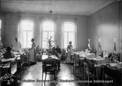 Manlig sjuksal på kirurgiska kliniken i Lund efter ombyggnaden 1905
Påskrift: "Plats för 10 patienter." Foto Rahmn, Lund, monterat på kartong. Läkaren är troligen Gustaf Petrén.
Nyckelord: Kapsel 02;Regionarkivet;Lasarettet;Lund;Kirurgi;Kirurgisk;Klinik;Gustaf,Petrén;