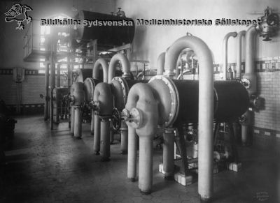 Panncentralen från år 1918 vid Lasarettet i Lund
Nya ångpannehuset. Apparaterna förefaller vara stora värmeväxlare. Fotografi monterat på pappskiva. Foto Otto Ohm Malmö, troligen då anläggningen var ny.
Nyckelord: Kapsel 03;Regionarkivet;Lasarettet;Lund;Panncentral;;Service