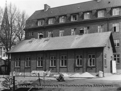 Barnklinikens isoleringspaviljong och 1929 års kök, södra lasarettsområdet i Lund
Barnklinikens isoleringspaviljong framför söderfasaden på köket från 1926. Fotografi monterat på styv kartong.
Nyckelord: Kapsel 03;Regionarkivet;Lasarettet;Lund;Barn;Barnklinik;Infektion;Isoleringsavdelning;Centralkök