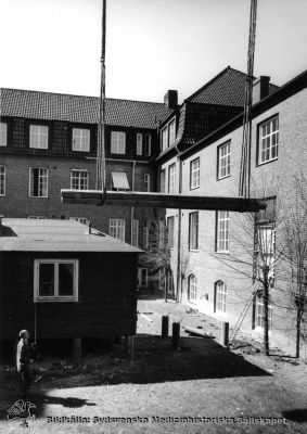 En barack lyfts i delar ut ur en av medicinklinikens innergårdar
En barack för ett forskningslaboratorium lyfts ut ur en av innergårdarna på dåvarande medicinska klinikens byggnad 1968. Fotografi monterat på styv kartong.
Baracken hade byggts i mitten på 1900-talet. Enligt uppgifter framkomna 2014 skall bilderna från baracklyftandet ha tagits 1968, samma år som medicinska kliniken flyttade in i centralblocket. Rimligen visar bildserien alltså hur baracken togs bort. Fil SMHS12285 kommer från samma negativ.
Nyckelord: Kapsel 03;Regionarkivet;Lasarettet;Lund;Medicin;Klinik;Barack;Forskning;Laboratorium