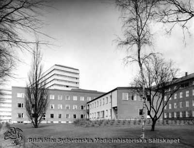 Barnpsykiatriska kliniken, från 1986 Ögonkliniken B
Påskrift: "Barnpsykiatrisk klinik. Foto i lasarettsarkivet." Fotografi monterat på tjock kartong. Foto från sydost. Årtal saknas, men kliniken invigdes i oktober 1965. Det bakomliggande centralblocket vid Lasarettet i Lund stod färdigt 1968. Bilden bör alltså vara tagen tidigast på sent 1960-tal eller senare; senast 1985 då huset började göras om till ögonmottagning, sedan barnpsykiatrin hade flyttats ned till St Lars-området.
Nyckelord: Kapsel 03;Regionarkivet;Lasarettet;Lund;Barnpsykiatrisk;Klinik;Ögon;