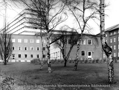 Barnpsykiatriska kliniken, från 1986 Ögonkliniken B
Påskrift: "Barnpsykiatrisk klinik. Foto i lasarettsarkivet." Fotografi monterat på tjock kartong. Foto från sydost. Årtal saknas, men kliniken invigdes i oktober 1965. Det bakomliggande centralblocket vid Lasarettet i Lund stod färdigt 1968. Bilden bör alltså vara tagen tidigast på sent 1960-tal eller senare; senast 1985 då huset började göras om till ögonmottagning, sedan barnpsykiatrin hade flyttats ned till St Lars-området.
Nyckelord: Kapsel 03;Regionarkivet;Lasarettet;Lund;Barnpsykiatrisk;Klinik;Ögon;