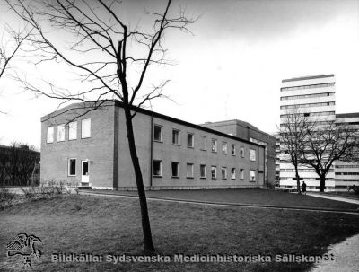 Barnpsykiatriska kliniken, från 1986/87 Ögonkliniken B
Påskrift: "Barnpsykiatrisk klinik. Foto i lasarettsarkivet." Fotografi monterat på tjock kartong. Foto från sydost. Årtal saknas, men kliniken invigdes i oktober 1965. Det bakomliggande centralblocket vid Lasarettet i Lund stod färdigt 1968. Bilden bör alltså vara tagen tidigast på sent 1960-tal eller senare; senast 1985 då huset började göras om till ögonmottagning, sedan barnpsykiatrin hade flyttats ned till St Lars-området. 
Från samma negativ som bilderna samma som bilderna SMHS2674_000_01Copp och SMHS12716, det senare med fotodatum känt: 20/4 1967.
Nyckelord: Kapsel 03;Regionarkivet;Lasarettet;Lund;Barnpsykiatrisk;Klinik;Ögon;