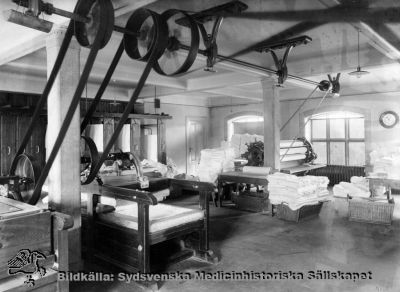 Tork- och mangelrum i tvätteriet på södra lasarettsområdet i Lund 1906
Påskrift: Tork- och mangelrum, Gaml. las. Serviceenheter, tvätt. Södra området". Foto Lina Jonns Eftr 1906 (Per Bagge). Fotografi monterat på pappskiva.
Nyckelord: Kapsel 03;Lina;Jonn;Per;Bagge;Lasarettet;Lund;Södra;Område;Tvätt;Mangel;1906