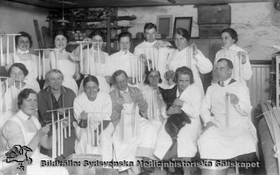 Ljusstöpning av vårdpersonal i Lund i början av 1900-talet
Påskrift: "Personal LL". Foto med tryck på baksidan som för ett postkort av den typ som var vanlig under 1900-talets första halva. Frisyrerna och kläderna antyder samma tidsperiod, kanske närmare mitten av 1900-talet än i dess början. Ingen annan indexeringshjälp.
Nyckelord: Kapsel 04;Personal;Foto;Omonterat;Postkort;Julstök;Ljusstöpning;Universitetssjukhuset;Lund