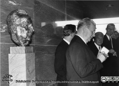 Landstingsmannen Torsten Andrée vid skulpturen av honom själv.
 Foto i entréhallen till c-blocket på Lasarettet i Lund, rimligen i samband med invigningen 1968. Bortom honom troligen Emil Ahlquist (landstingets ordf) och Bengt Borgström (dåvarande dekanus).
Nyckelord: Lasarettet;Lund;Kapsel 17;Torsten;Andrée;Centralblocket;Invigning;1968