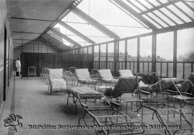 Ortopediska kliniken i Lund i mitten av 1900-talet
 solningsverandan med upprullat tak och nerfällda fönster. Fotograf: Otto Ohm Malmö. Originalfoto i mitten på 1900-talet. Monterat.
Nyckelord: Kapsel 18;Ortopedi;Lasarettet;Lund;Tuberkulos;Behandling;Tbc