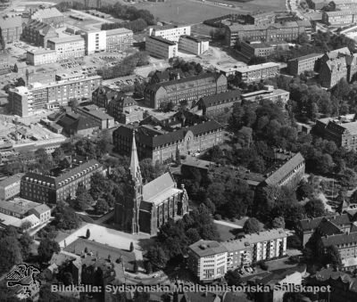 Flygfoto över norra lasarettsområdet i Lund, från sydväst
I nedre hörnet ses Allhelgonakyrkan. I bildens ovandel centralblockets laboratorieflygel, A-B blocket och där framför området för de blivande C-D blocken. Foto i mitten på 1960-talet
Nyckelord: Kapsel 18;Lund;Lasarett;Norra;Området;Flygfoto