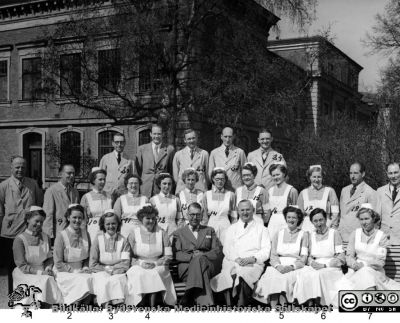 Kursfoto, mentalvårdare, St Lars
Kapsel 20. Påskrift: "1. Stina Lundell, Vipeholm 2. Elsa Jönsson 11 (3) Ester Olsson, 4 Ulla-Greta Nilsson, 5 Göta Berg, 6 Klara Molin-Nilsson, 7 Inga Wadbo, 8 Rolf Hällen, Vipeholm, 9 Rickard Eklund, 10 Märta Karlsson, Vipeholm, 3 (11) Anna Carlsson, 12 Ing-Britt Larsson, 13 Margit Ekholm, 14 Signe Persson, 15 Edith Persson, 16 Karin Ek, 17 Astrid Fridh, 18 Stig Mattsson,  19 Roland Stark Vipeholm, 20 Bertil Kullberg,Vipeholm 21 Kjell Ekström, 22 Edvin Persson, 23 Kjell Englesson, 24 Tore Cronqvist". Rimligen kursfoto från en skötarkurs på St Lars i Lund. Herrarna i främsta ledet är professor Gunnar Wohlfart och docent Bo Gerle. Foto i mitten på 1900-talet, före 1961 då Wohlfart dog. Originalfoto, Monterat
Nyckelord: Kapsel 20;Personal;Utbildning;St Lars;1900-talet