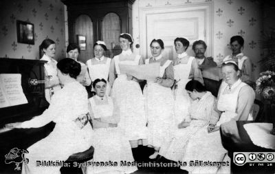 Interiör från kvinnliga förstaklassavdelningen på St Lars år 1921
Kapsel 21 med bilder från St Lars i Lund. Påskrift: "Kvinnoavd. I klass 1921". Originalfoto med vykortstryck på baksidan, aldrig använt. Ej monterat. - På en annan bild noteras mannen vara "Olsson som skötte fåglarna".
Nyckelord: Kapsel 21;St Lars;Lund;Personal;Patient;Mentalvårdare;Sköterskor